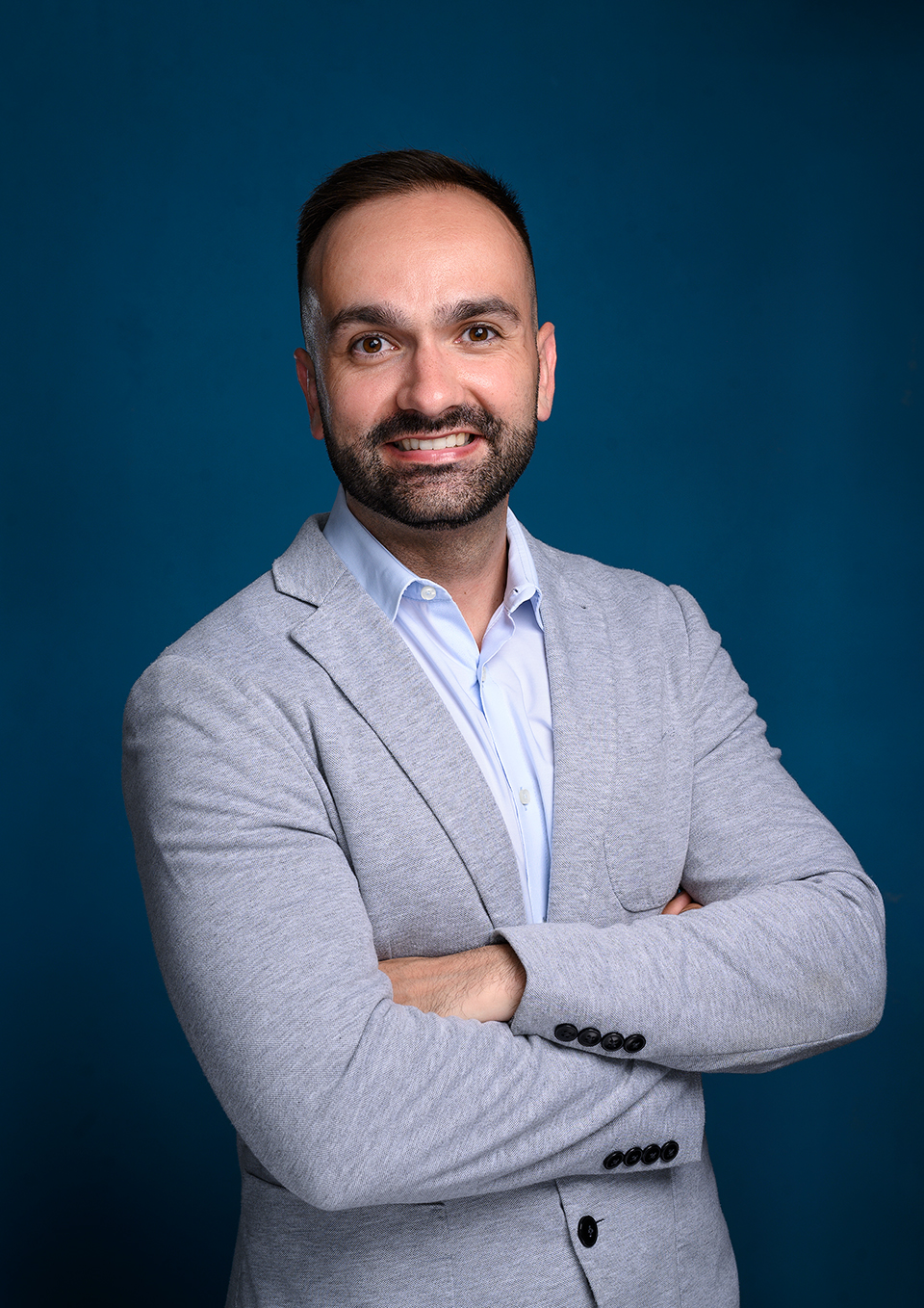 Jonathan Serrano's business portrait in a second jacket, London studio, dark blue backdrop
