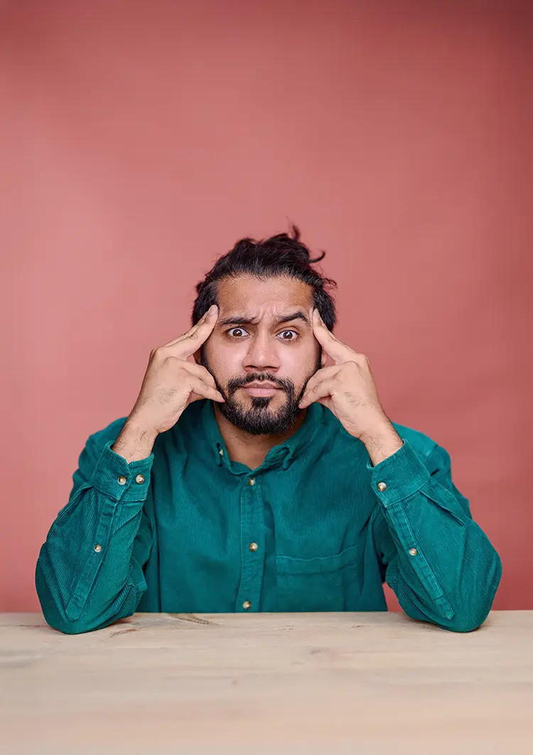 Comedian Sunny Dhesi's studio portrait, taken in my South East London studio with a table and terracotta canvas backdrop.