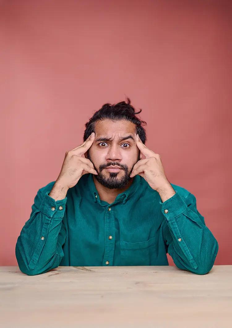Comedian Sunny Dhesi's studio portrait, taken in my South East London studio with a table and terracotta canvas backdrop.