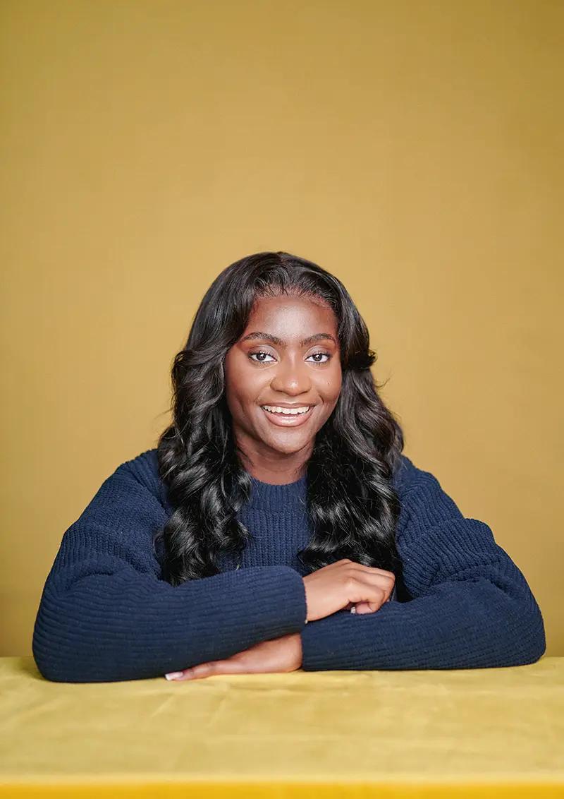 Portrait of author Faith Gomes captured in my London studio, with a yellow backdrop