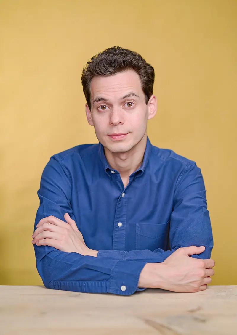 Portrait of author and BBC presenter William Adams in my Herne Hill studio with a table and yellow canvas backdrop.