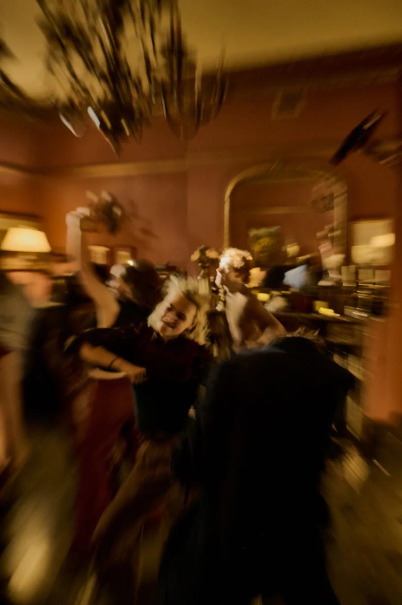 Cast dancing in a candlelit room, captured with motion blur during filming
