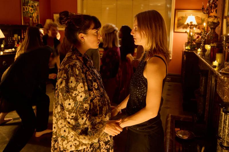 Two actors in character holding hands during a scene in a candlelit room