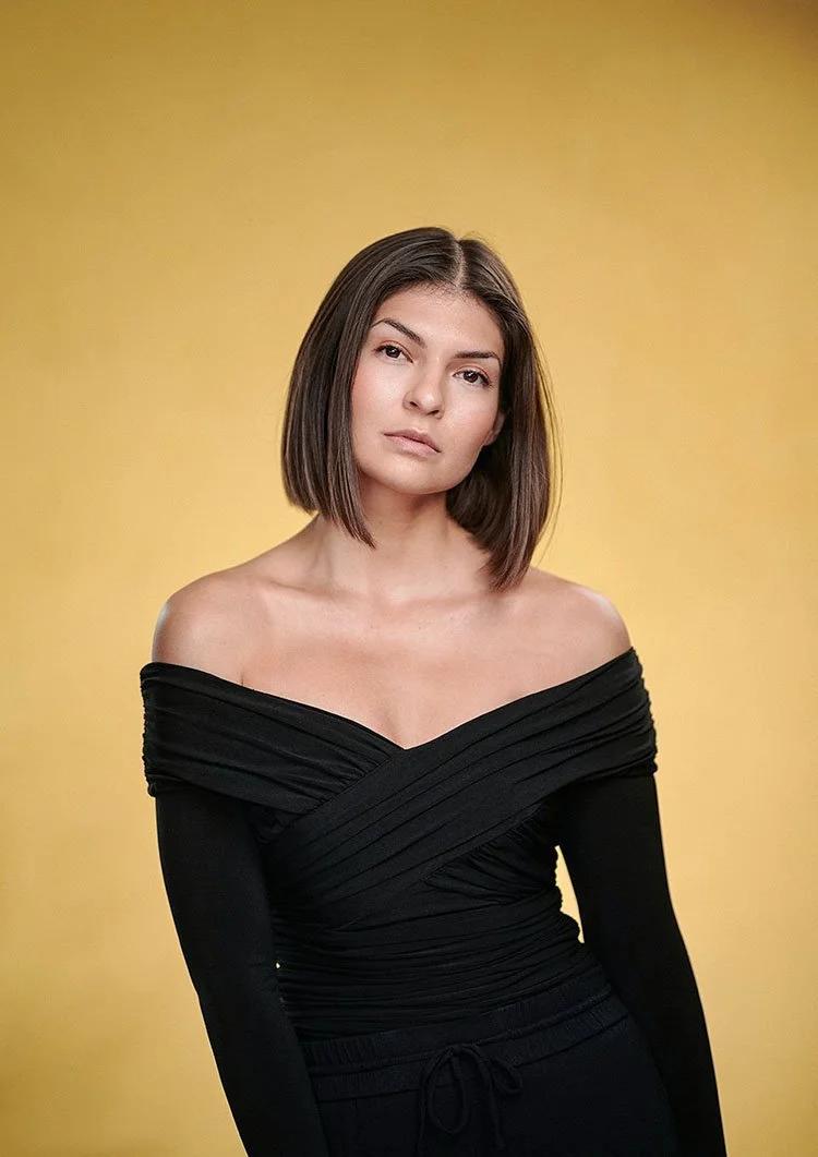 Model portfolio portrait photographed in London studio with clean light and custom yellow canvas backdrop