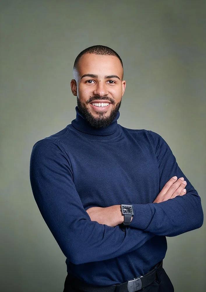 Business portrait of man in studio with professional lighting and green canvas backdrop.