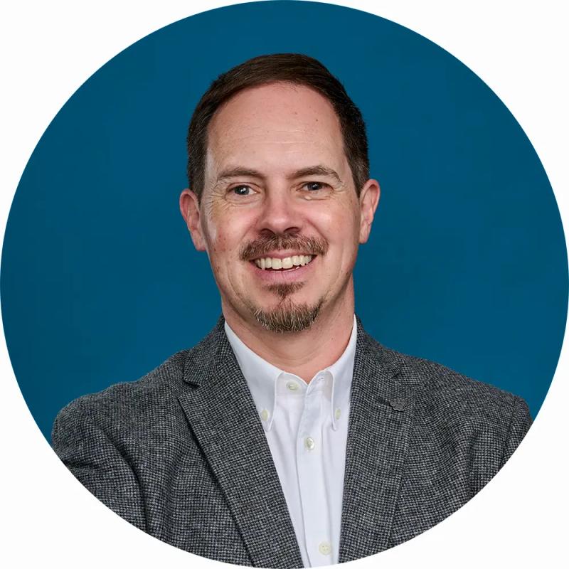 LinkedIn Headshot of Businessman in London Studio with blue canvas backdrop.