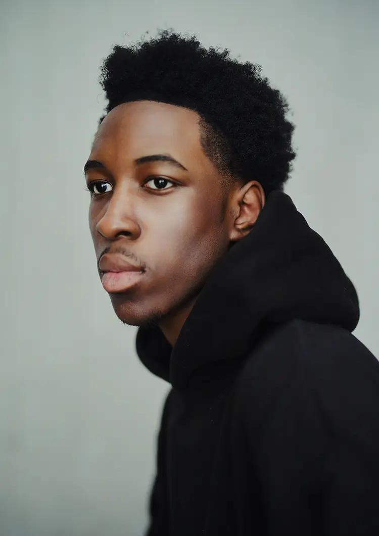 Portrait of male model looking off-camera in my London studio, with a light background and soft light. 