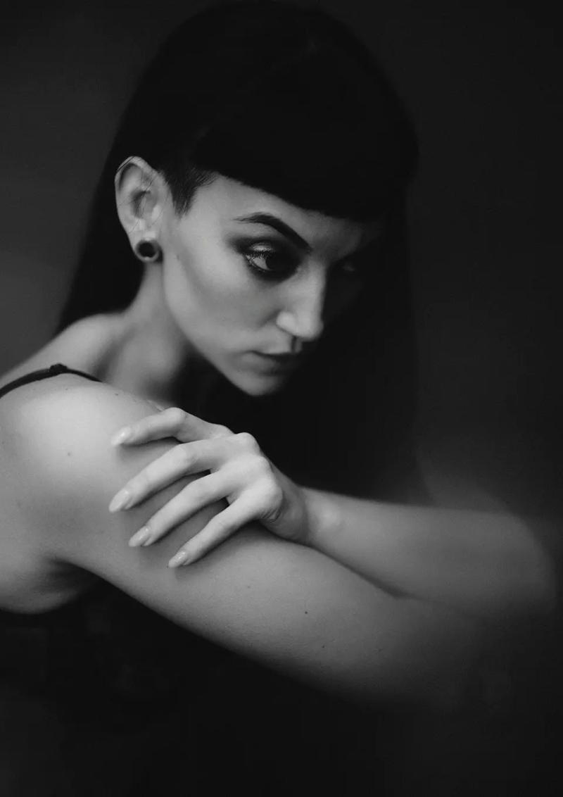 Black and white portrait of model in London studio with soft natural light.