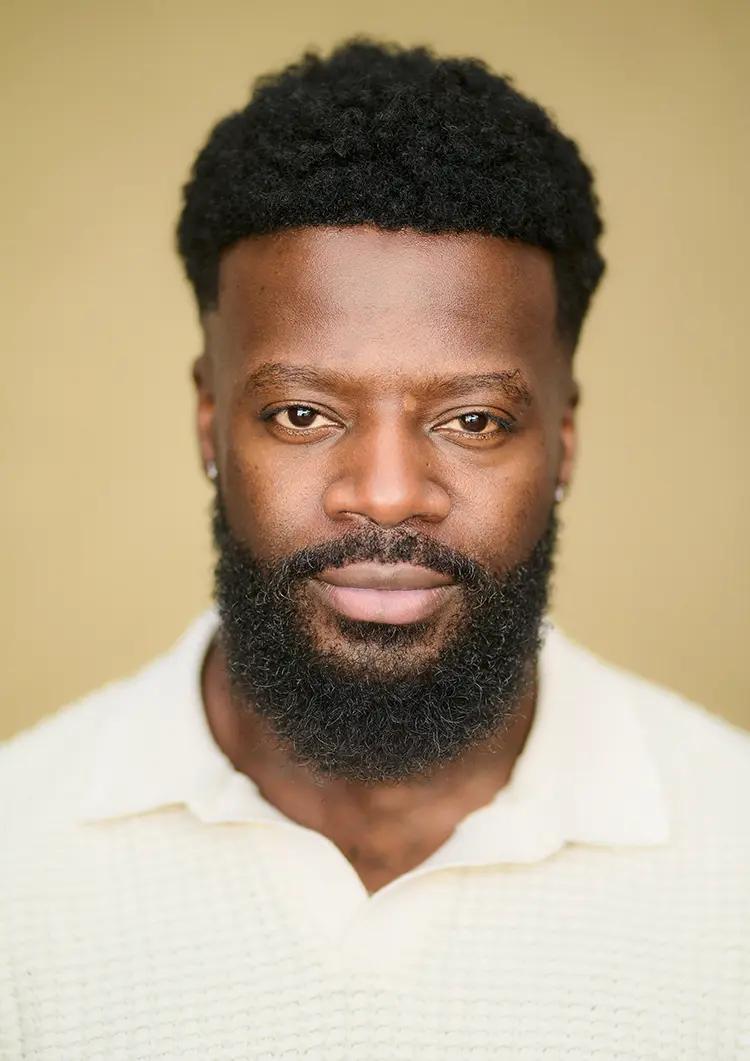 Actor headshot of Kieran Shekoni against an ochre canvas backdrop in my London studio.